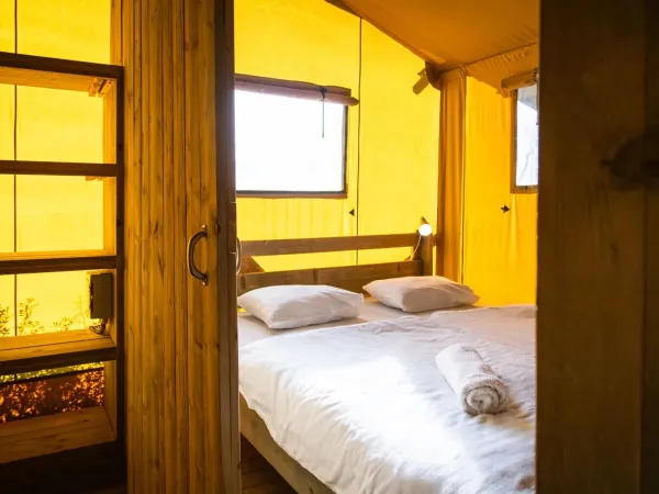 De Roan Lodgetent Premium XL slaapkamer met ruim tweepersoonsbed.