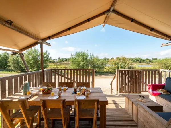 De Roan Lodgetent Luxe beschikt over een veranda met loungebank.
