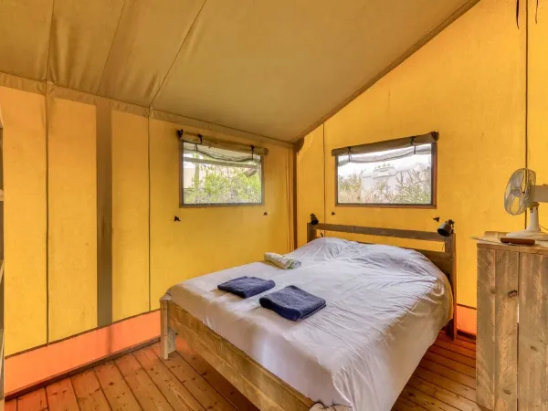 De Roan Lodgetent Luxe slaapkamer met een tweepersoonshemelbed.