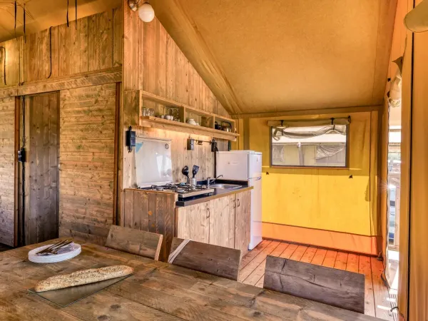 De Roan Lodgetent Luxe beschikt over een stevige eettafel met stoelen.