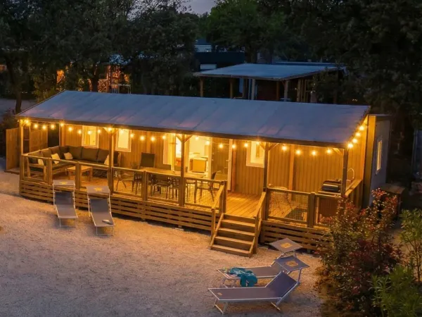 De Supreme Deluxe Lounge Premium Zone met sfeerverlichting op de veranda.