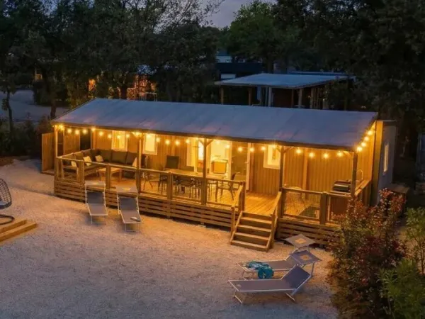 De Supreme Deluxe Lounge Premium Zone met sfeerverlichting op de veranda.