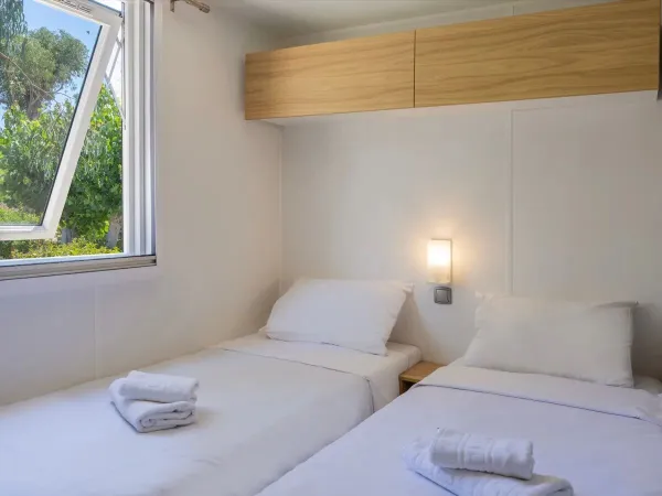 Een slaapkamer met eenpersoonsbedden in de Roan stacaravan Supreme met 2 badkamers.