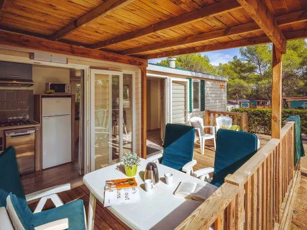 Het ruime terras van de Comfort plus is ingericht met een tafel en meerdere stoelen.