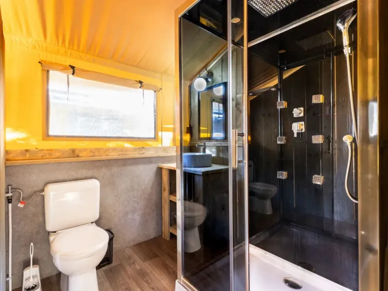De Roan Lodgetent Premium XL badkamer beschikt over luxe douchecabine, toilet en wastafel.