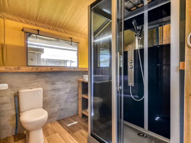 De Roan Lodgetent Luxe beschikt over een douchecabine, toilet en wastafel.