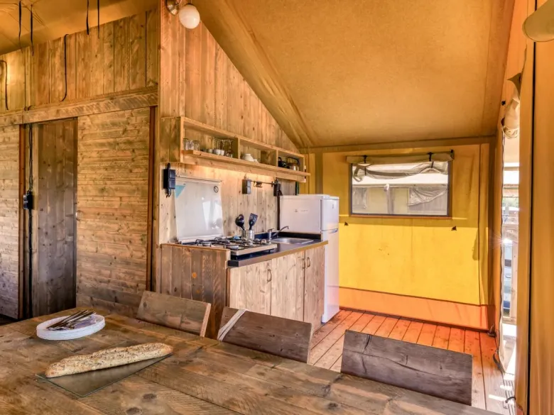 De Roan Lodgetent Luxe beschikt over een stevige eettafel met stoelen.