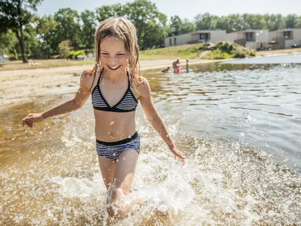 Meisje loopt door natuurbad bij Roan camping De Schatberg.