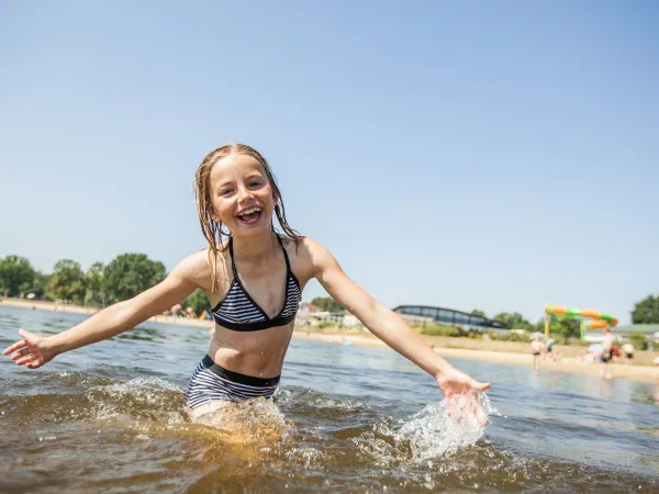 Meisje zwemt in natuurbad bij Roan Luxury Camping De Schatberg.