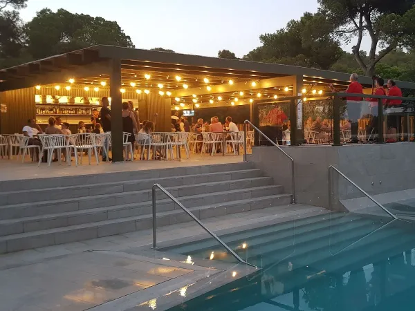 Terras bij het zwembad in de avond op Roan camping Cala Gogo.