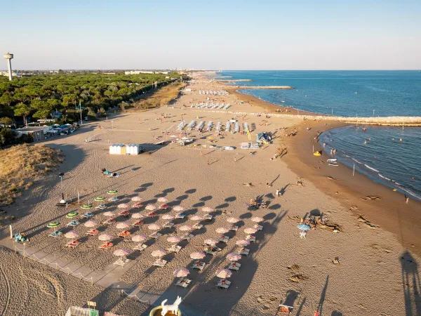 Ligbedden op het strand bij Roan camping Union Lido Mare.