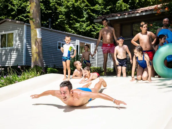 Glijdende jongen op Roan camping hu I Pini village.