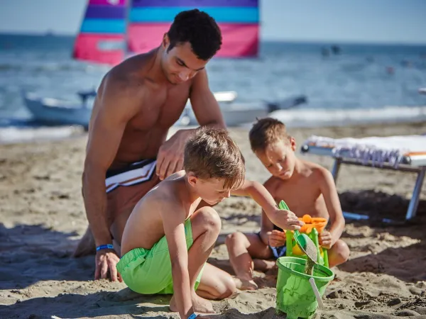 Genietende kinderen bij het strand van Roan camping Mediterraneo.