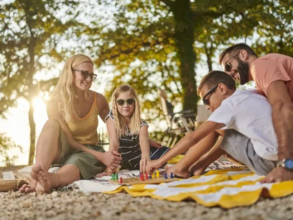 Gezin speelt bordspel bij Roan camping Zelena Laguna.