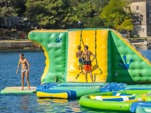 Plezier op het waterspeelkussen in zee bij Roan camping Lanterna.