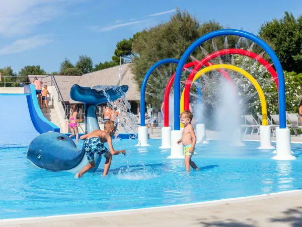 Spelende kinderen in kinderzwembad op Roan camping San Francesco.