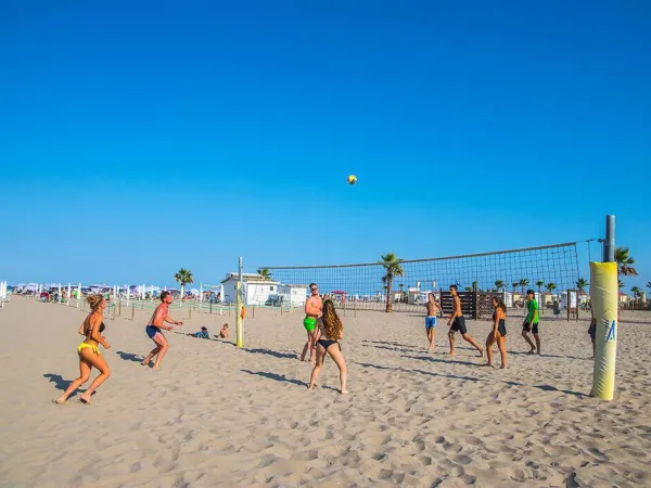 Vakantiegangers spelen beachvolleybal op Roan camping Sole Family Camping Village.