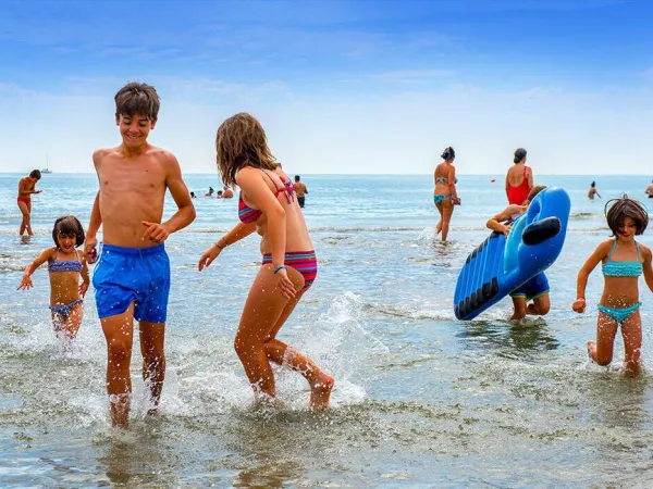 Kinderen spelen in de zee op Roan camping Sole Family Camping Village.