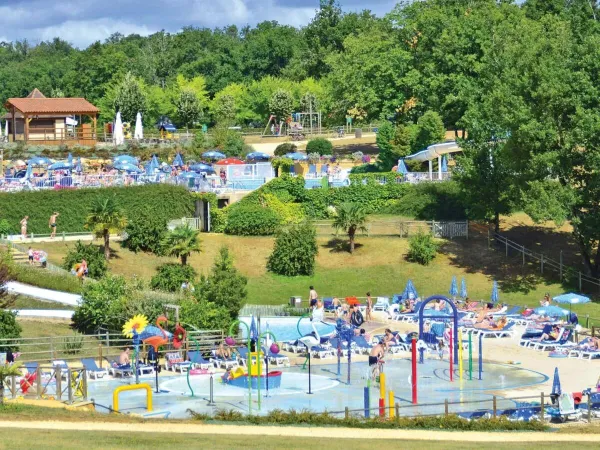 Overzicht van het waterpark en de zwembaden in de verte op Roan camping Saint Avit Loisirs