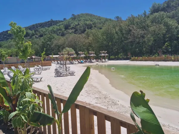 Lagunebad met zandstrand en ligbedden op Roan camping Verdon Parc.