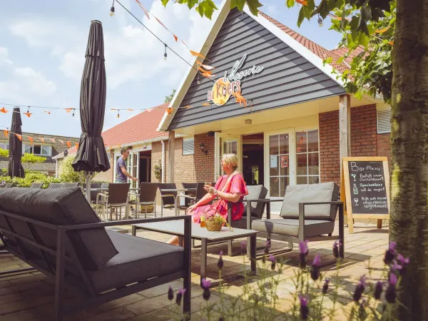 Borrelende mensen op het terras op roan camping 't Veld.