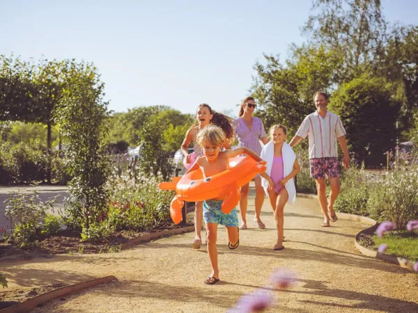 Familie op weg naar het zwembad op Roan camping Le Domaine du Clarys.