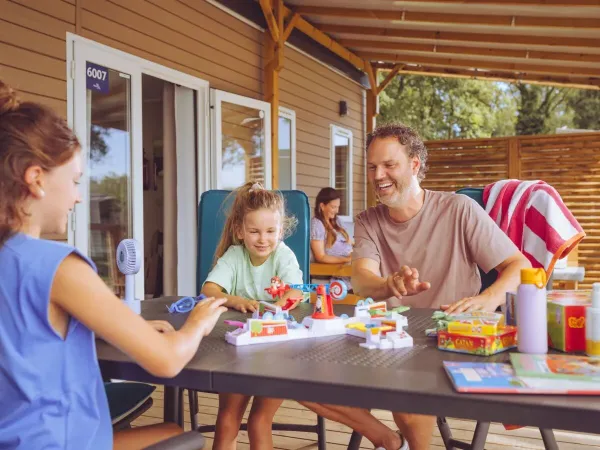 Familie speelt een spelletje op de veranda.