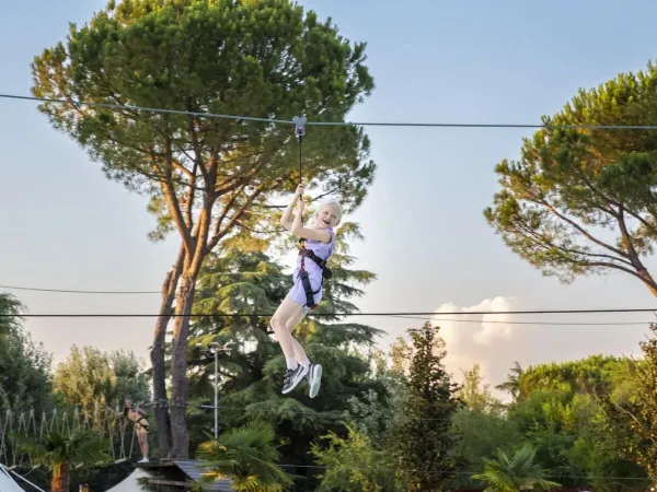 Ziplinen tussen de boomtoppen op Roan camping hu Altomincio village.