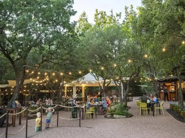 Zitgedeelte buiten bij het restaurant met gezellige lampjes op Roan camping hu Montescudaio village.