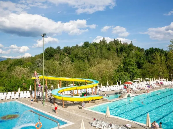 Zonneterras met semi-Olympisch zwembad en glijbaan op Roan camping hu Norcenni Girasole village.