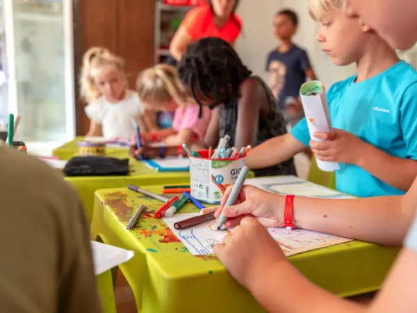 Kinderen aan het tekenen bij de Kids Club op Roan camping Château de Fonrives.