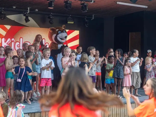 Vrolijk zingende kinderen op podium op Roan camping Château de Fonrives.