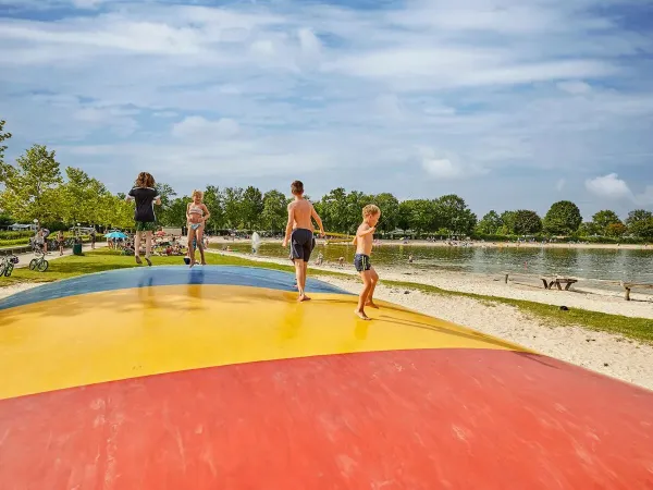 Airtrampoline met springende kinderen op het strand van Roan camping Terspegelt.