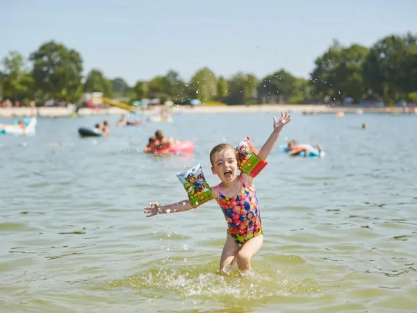 Blij meisje in de zwemplas op Roan camping Terspegelt.