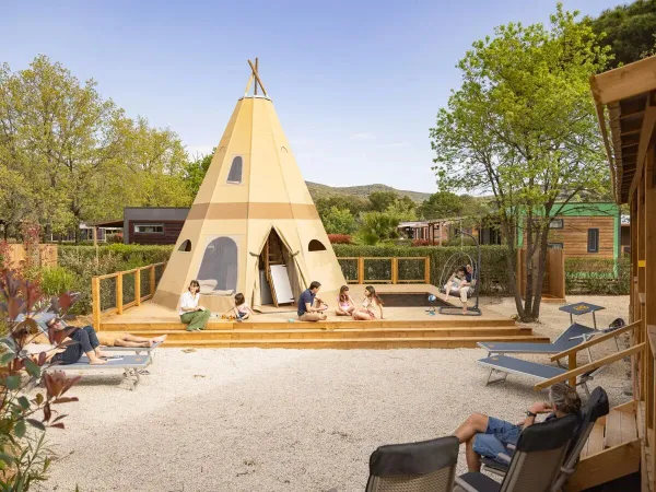 Families genieten van de ruimte rondom de Supreme Deluxe Family Premium Zone op Roan camping Domaine des Naïades.