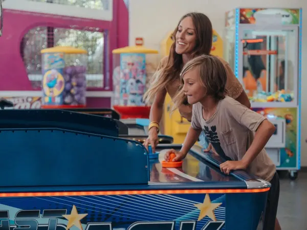 Moeder en zoon bij de speelautomaten op Roan camping Les Méditerranées Beach Garden.