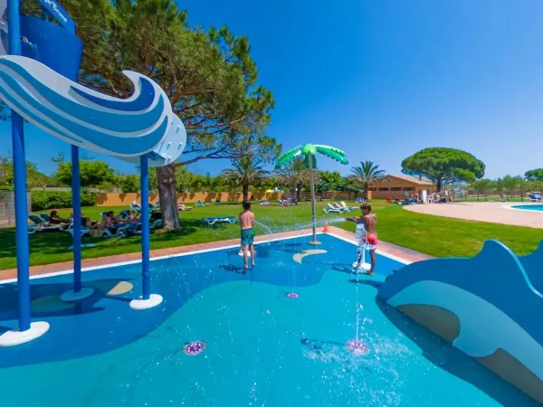 Spraypark en ligweide met ligbedjes in de schaduw op Roan camping Platja Brava.