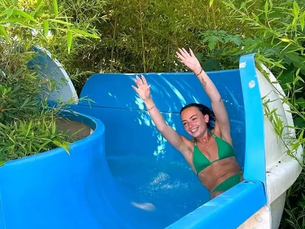 Meisje glijdt van de waterglijbaan op Roan camping Méditerranée Plage.