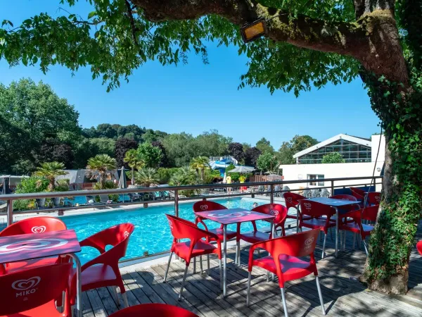 Het terras bij het zwembad op Roan camping Le Ty Nadan.