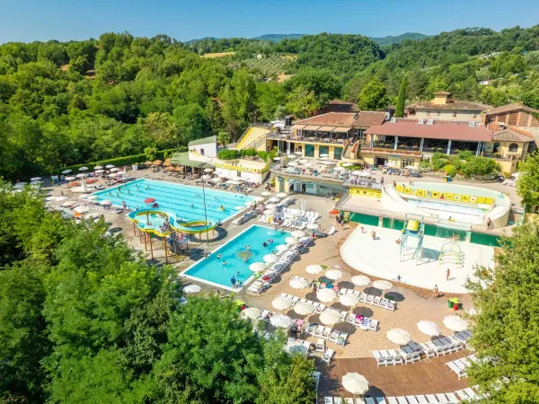 Zonneterras met semi-Olympisch zwembad en glijbaan op Roan camping hu Norcenni Girasole village.