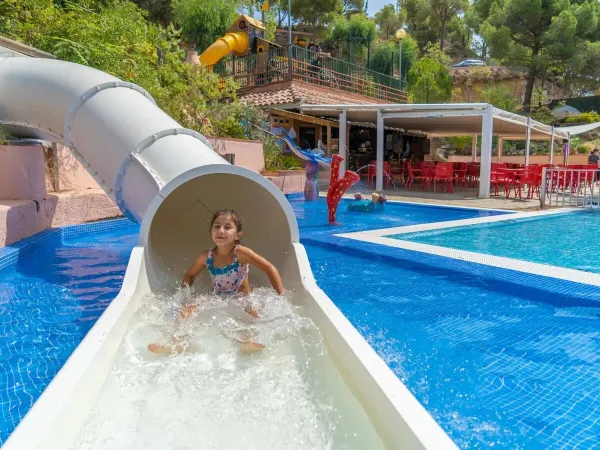 Meisje op de zwembadglijbaan op Roan camping Cala Canyelles.