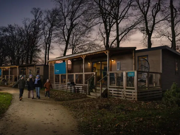 Kinderen wandelen langs de sfeervolle stacaravans in de winter op Roan camping Marilla Parks Kaatsheuvel.
