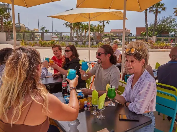 Proostende mensen op het terras van Roan camping Le Petit Mousse.