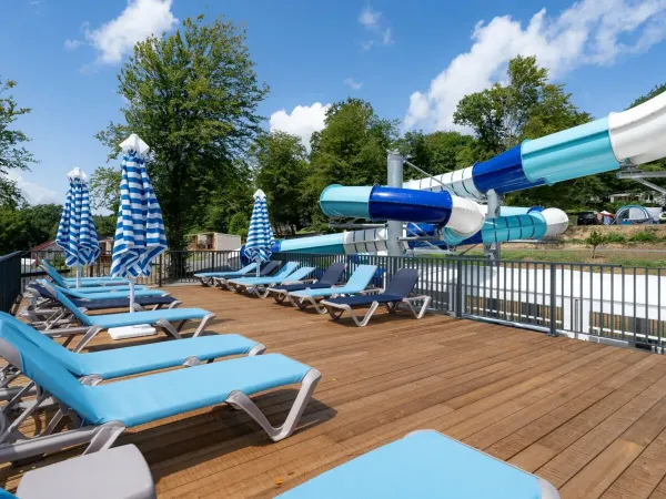 Een zonneterras en glijbaan op Roan camping Le Lac des Vieilles Forges.