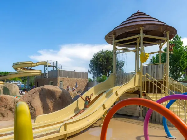 Meisje glijdt van de kinderglijbaan op Roan camping Arinella Bianca.