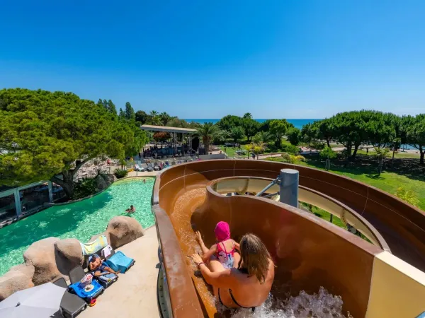 Moeder en kind glijden van de glijbaan op Roan camping Arinella Bianca.