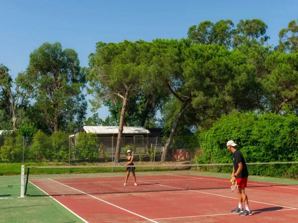 Man en vrouw spelen een potje tennis op Roan camping Arinella Bianca.