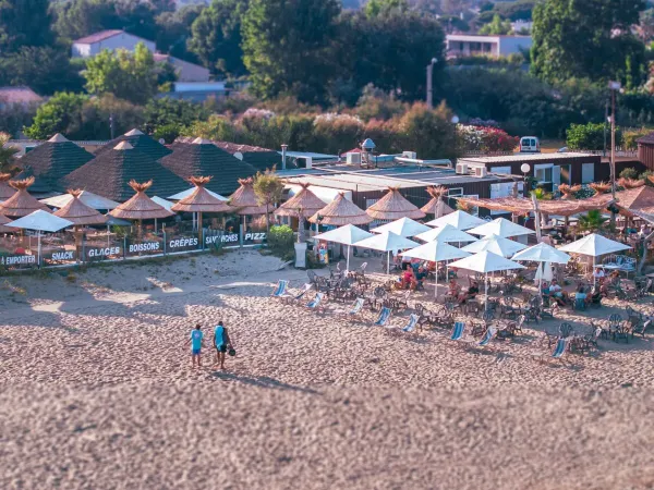 Het strand met parasols en ligbedjes op Roan camping Les Sables d'Or.