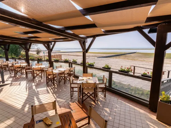 Restaurant met uitzicht op het strand en zee op Roan camping Tenuta Primero.