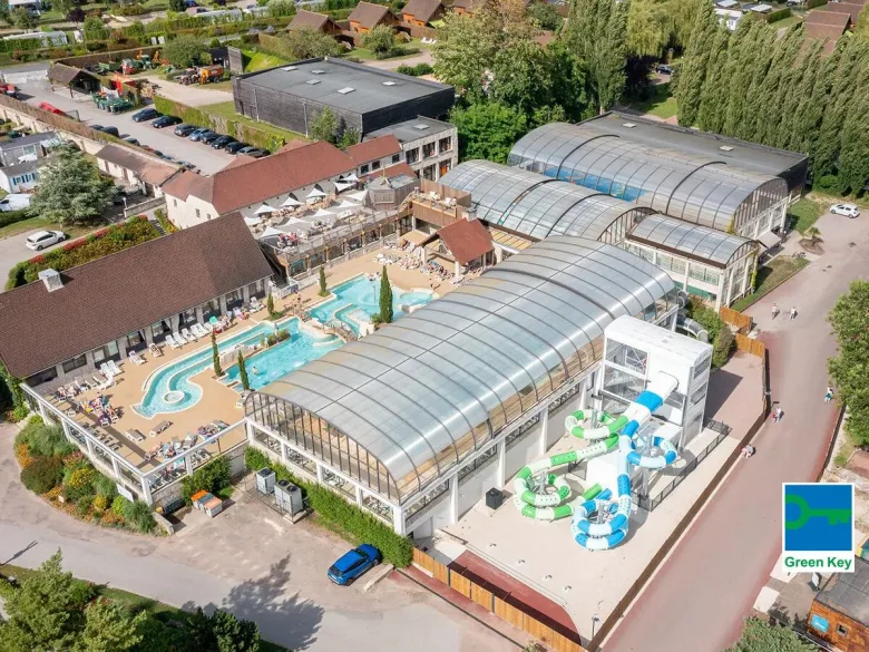 Overzicht van het binnen en buitenzwembad op Roan camping La Croix du Vieux Pont.